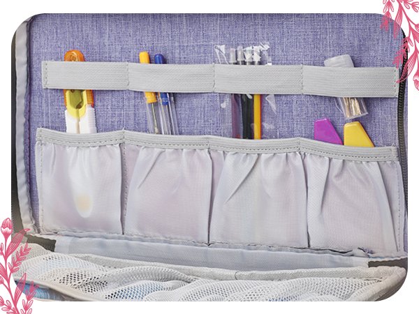 Embroidery and cross stitch organizer bag interior showing pockets filled with pens, scissors, needles, and other craft tools.