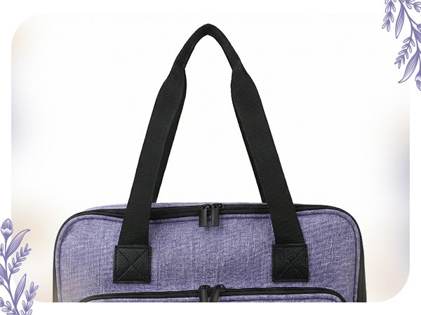 Close-up of a purple storage organizer bag with black handles and zippers, against a white background.