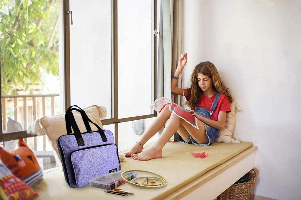 Girl reading a book while sitting next to an embroidery and cross stitch kit with a storage bag