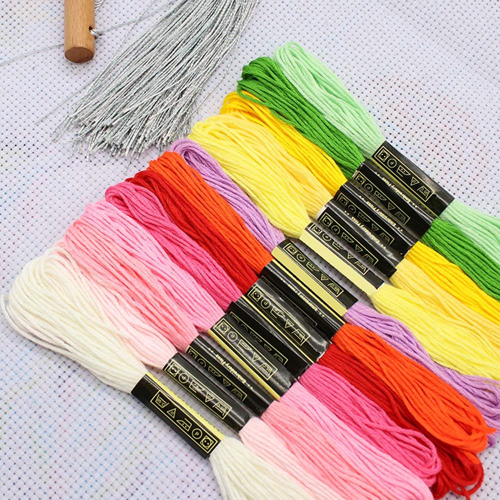 Embroidery floss in various rainbow colors arranged diagonally, with silver thread and a wooden tool at the top left.
