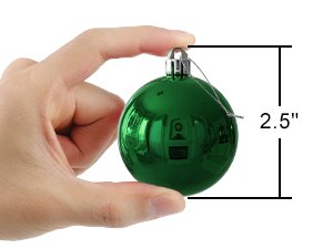 Hand holding a single emerald green shatterproof Christmas ball ornament with a size indicator showing 2.5 inches.