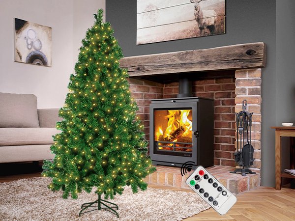 Lit Christmas tree with remote control in a cozy living room with a fireplace