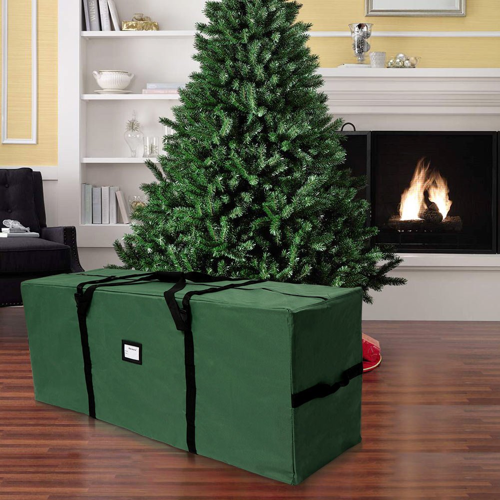 Extra large green Christmas tree storage bag in a living room with a fireplace and artificial tree.