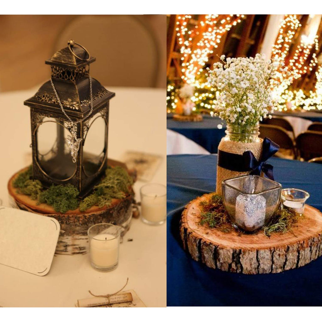 Two wedding table centerpieces featuring decorative moss, lanterns, candles, and floral arrangements on wood slices.