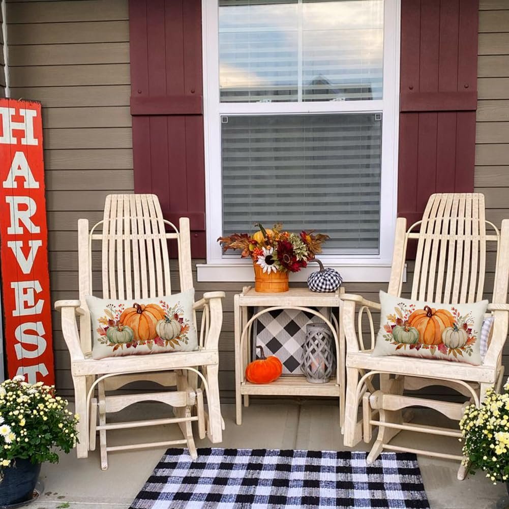 Fall harvest porch scene with two rocking chairs, a side table, and a vertical 'HARVEST' sign. Lumbar pillow with pumpkins on each chair.