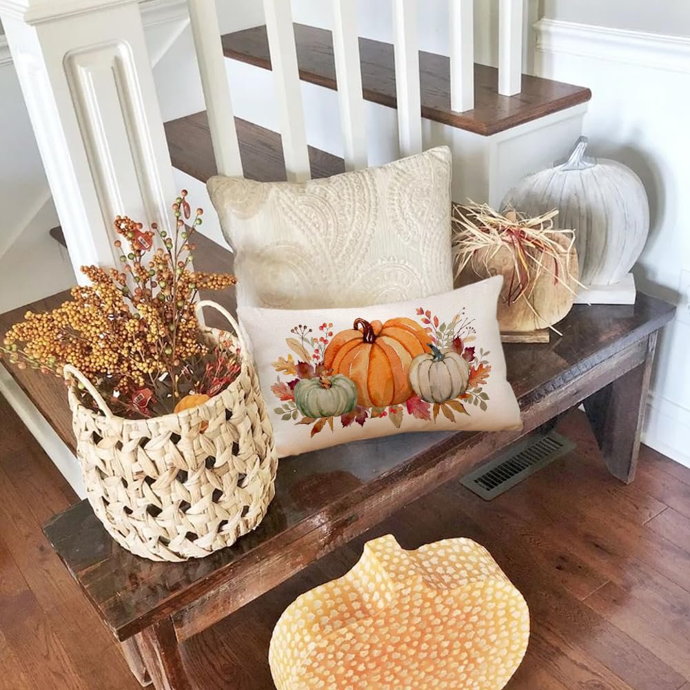 Lumbar throw pillow cover with pumpkins and maple leaves on a wooden bench with fall decor
