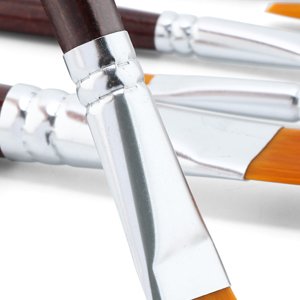 Close-up of several flat paint brushes with synthetic bristles and silver ferrules against a white background.
