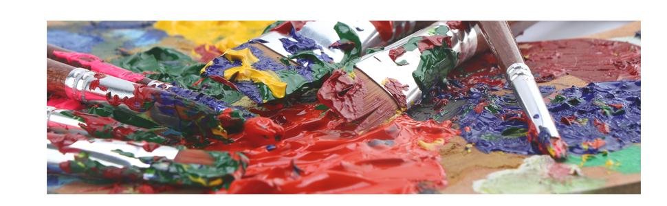 Close-up of paint brushes on a colorful art palette with thick blobs of red, blue, green, and yellow paint.