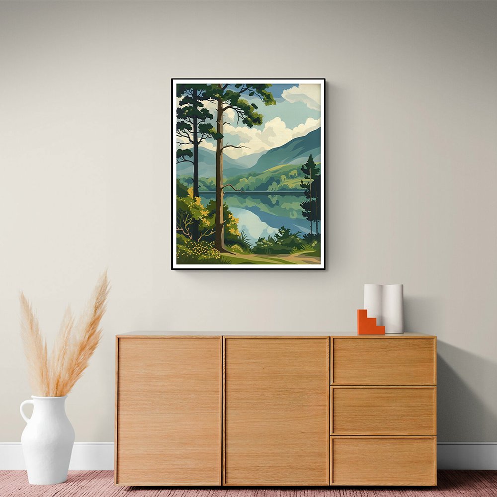 Framed forest landscape painting with a lake and mountains hanging above a wooden cabinet.