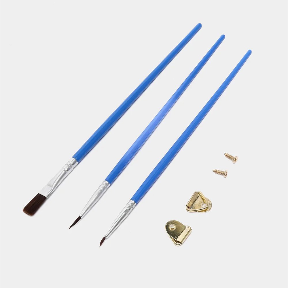 Three blue handled paint brushes and hardware for hanging a canvas on a white background