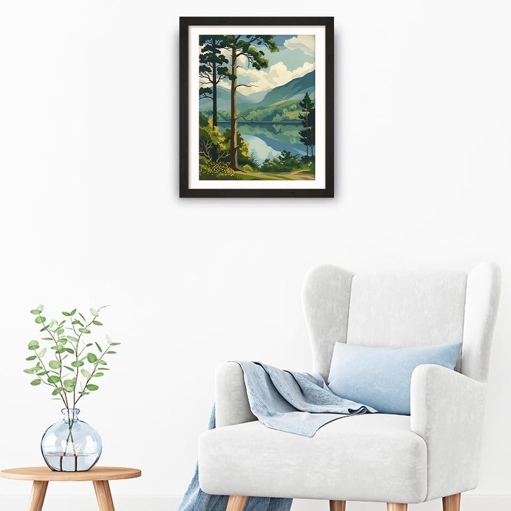 Framed forest landscape painting with lake and mountains hanging above a chair