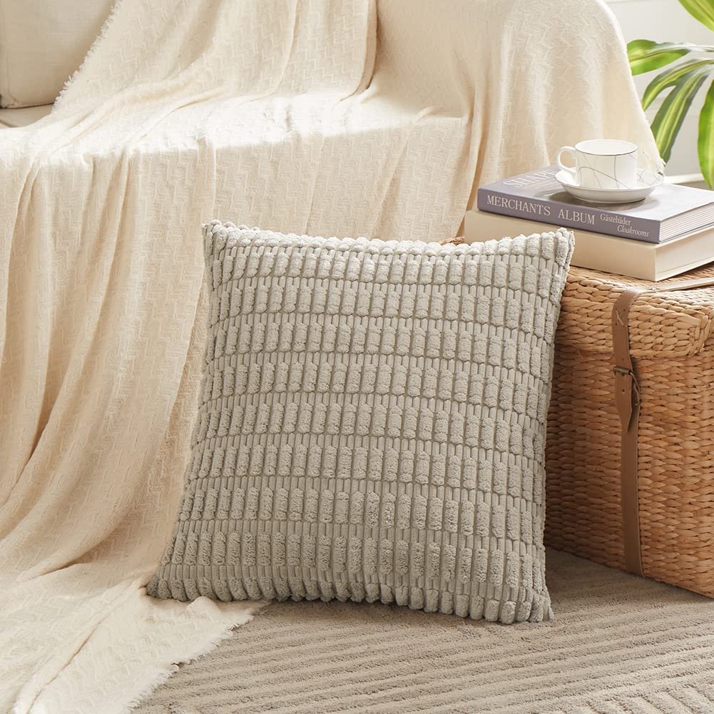 Gray textured throw pillow cover on a rug next to a woven basket and books.