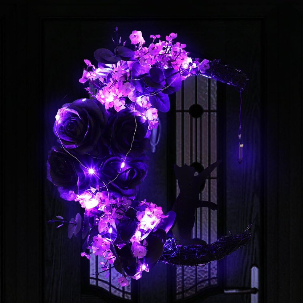Halloween moon wreath with black cat silhouette, purple roses, flowers, greenery, and LED lights on a dark door