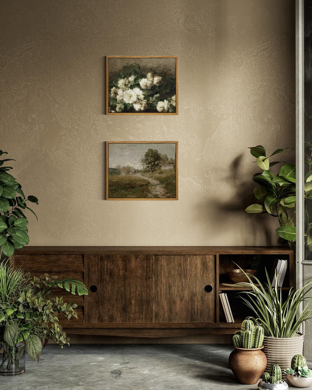 Two framed vintage botanical art prints hanging above a wooden credenza with plants.