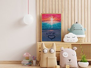 Diamond painting kit of a beach sunset scene with 'LOVE' written in the sand, displayed on a wooden shelf with plush toys.