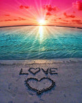 Beach sunset with 'LOVE' and a heart drawn in the sand