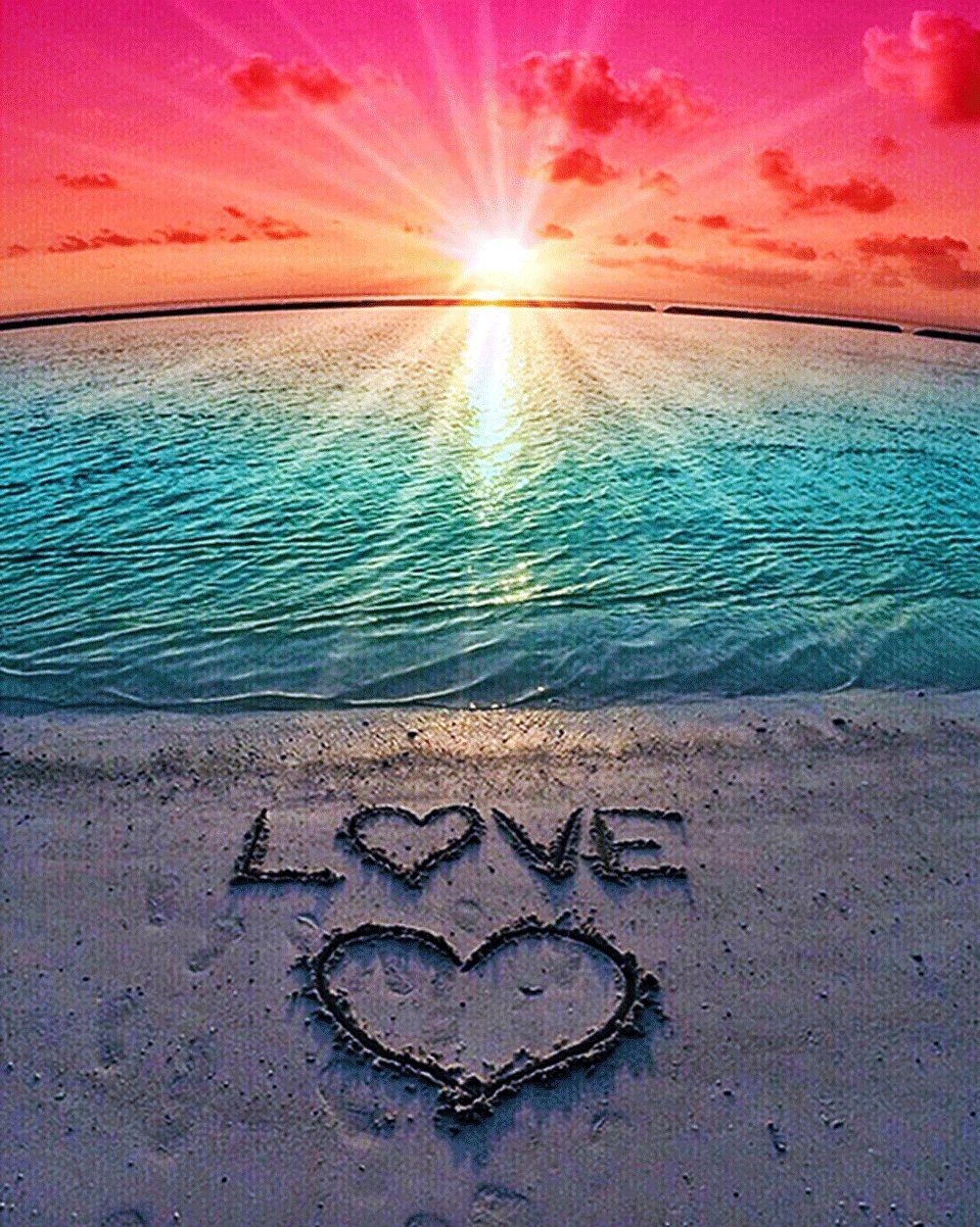 Beach sunset with 'LOVE' and a heart drawn in the sand