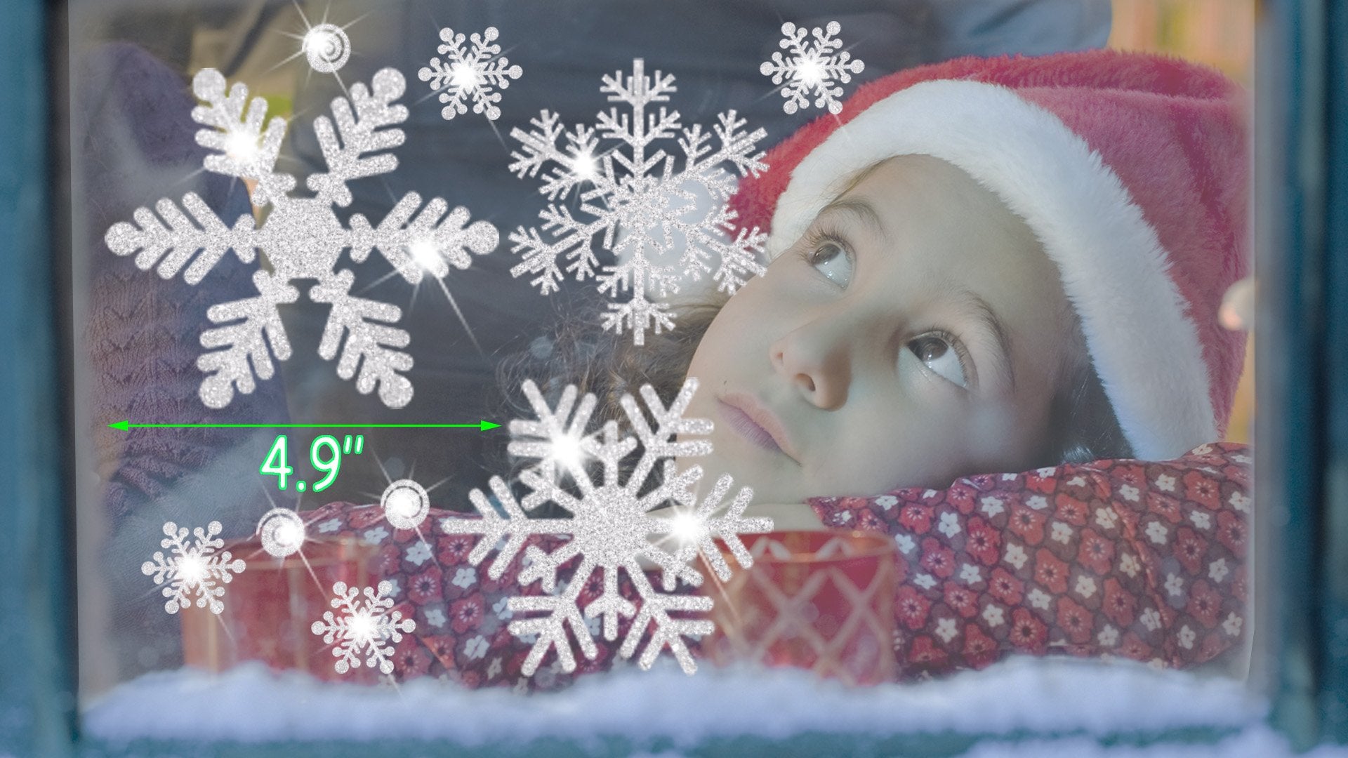Child in Santa hat looking up at glitter snowflake window clings, with a size indicator of 4.9 inches.