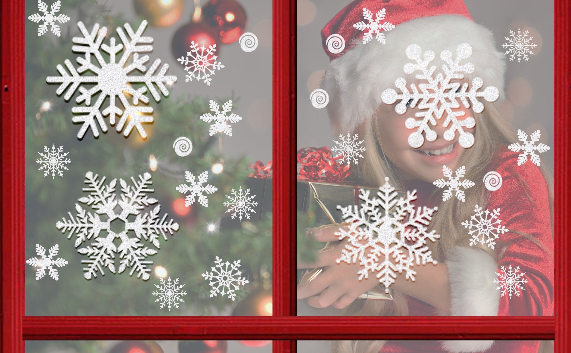 Glitter snowflake window clings on a window with a Christmas tree and a girl in a Santa hat holding a gift.