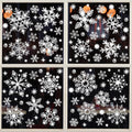 Glitter snowflake window clings arranged on a four-pane window, sparkling with light.
