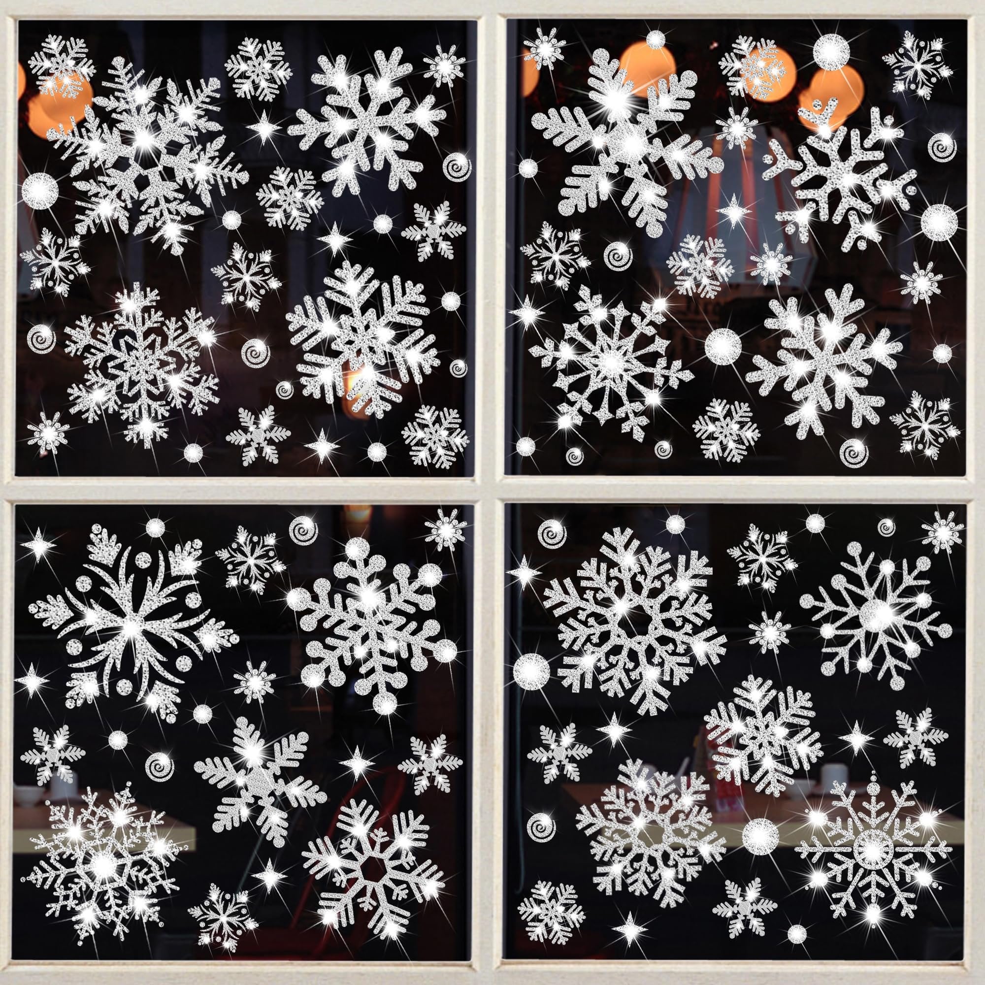 Glitter snowflake window clings arranged on a four-pane window, sparkling with light.