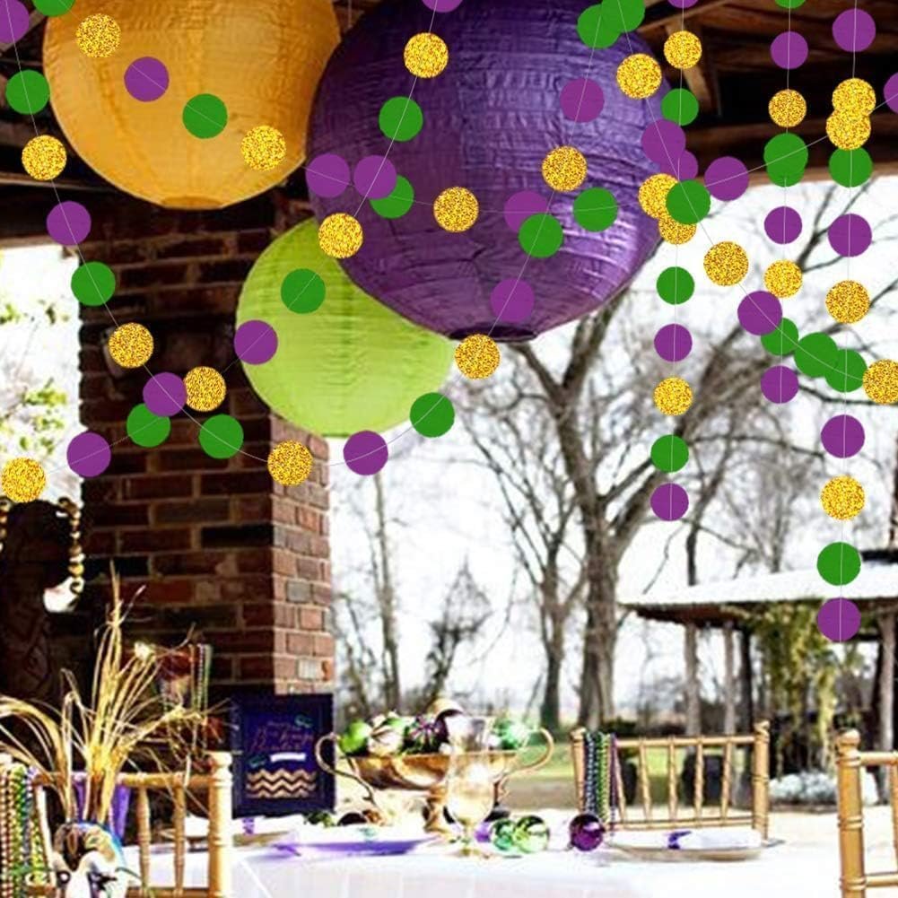 Gold, purple, and green glitter circle garland hanging with paper lanterns above a decorated table.