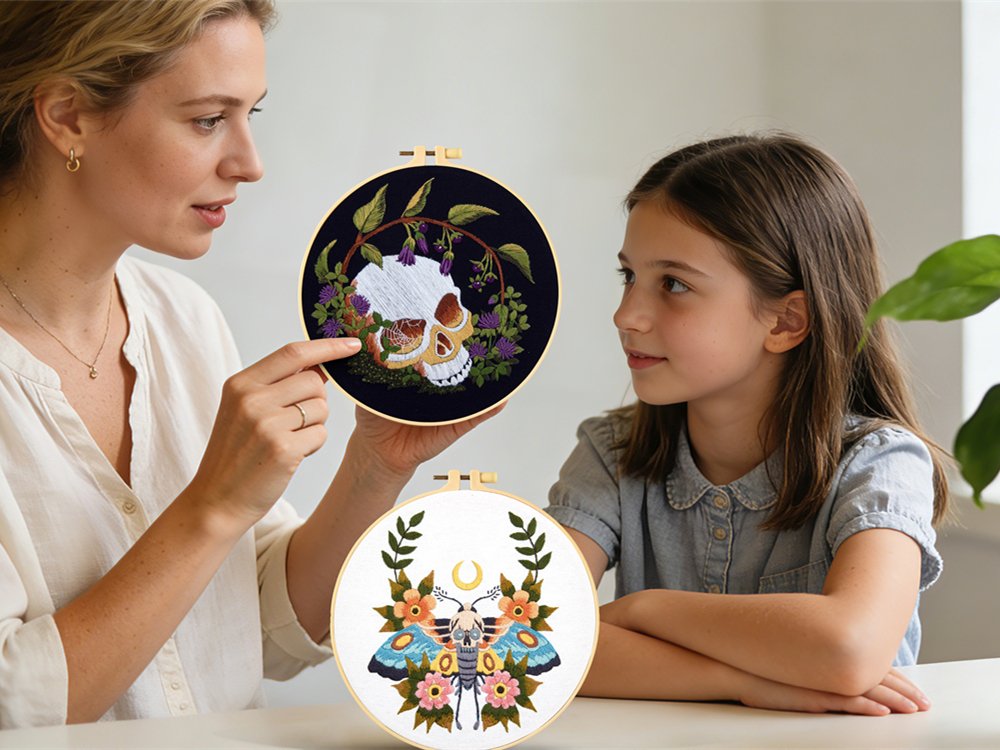 Woman showing a skull embroidery hoop to a girl with a moth embroidery hoop in foreground