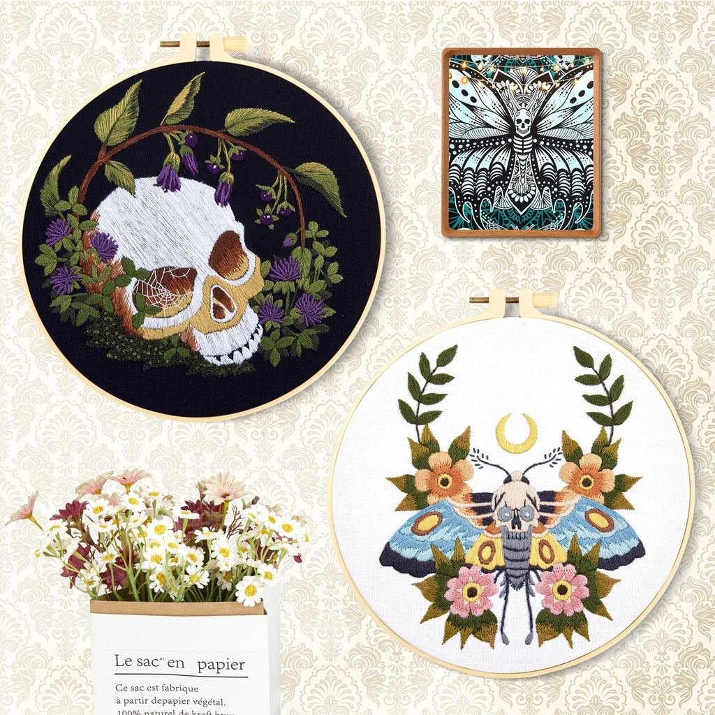 Embroidery hoops with skull and moth designs, framed artwork, and a bouquet of flowers in a paper bag.