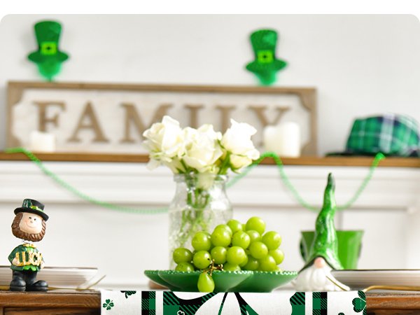 St. Patrick's Day table runner with shamrocks and plaid pattern, set on a table with decorations.