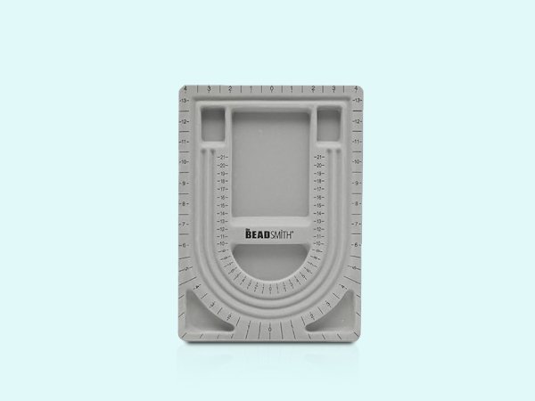 Grey flocked jewelry bead board with U-shaped channels and recessed compartments, featuring measurement markings.