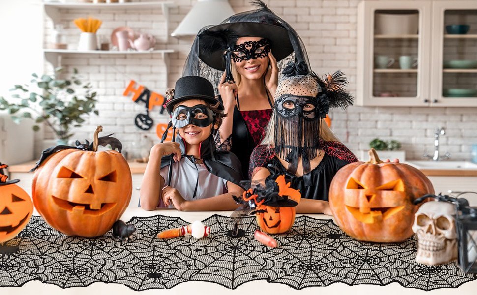 Halloween black lace spider web table runner displayed on a table with carved pumpkins, skulls, and people in costumes.