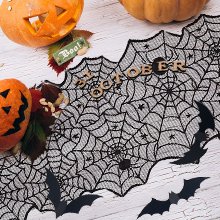 Halloween black lace spider web table runner with pumpkins and bats on a white wooden surface