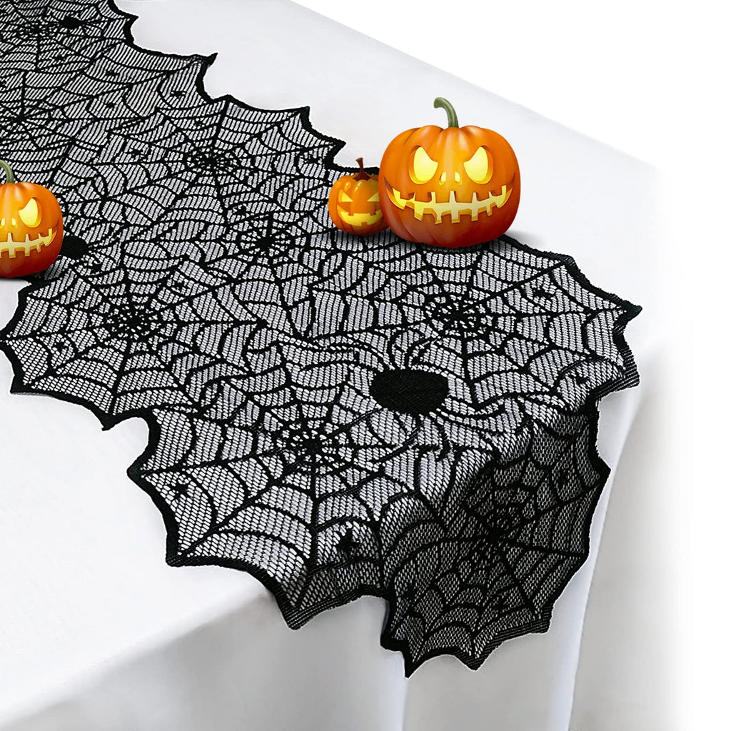 Black lace spider web table runner with decorative Halloween pumpkins on a white tablecloth