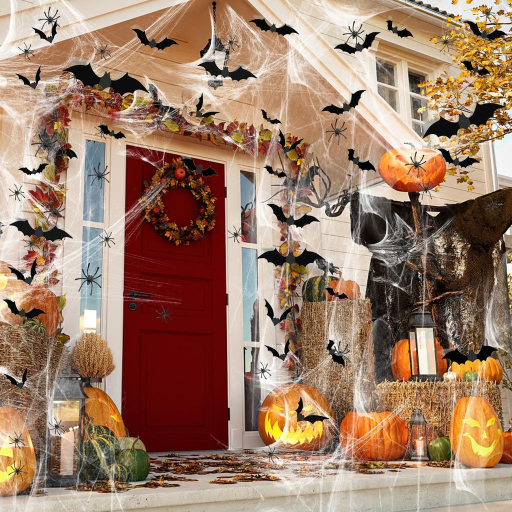 Halloween porch decorated with stretch spider webs, bats, spiders, pumpkins, and a wreath on the door.