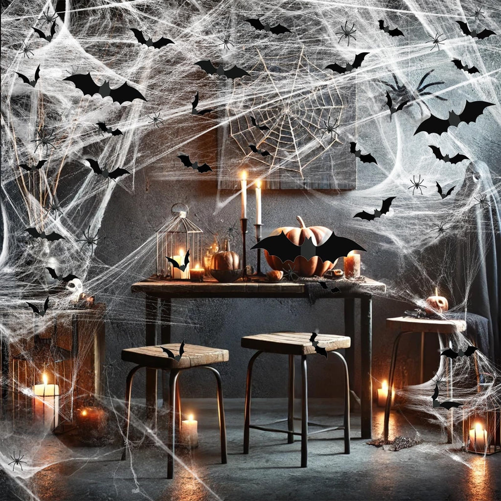 Halloween table setting with stretch spider webs, bats, spiders, pumpkins, and candles