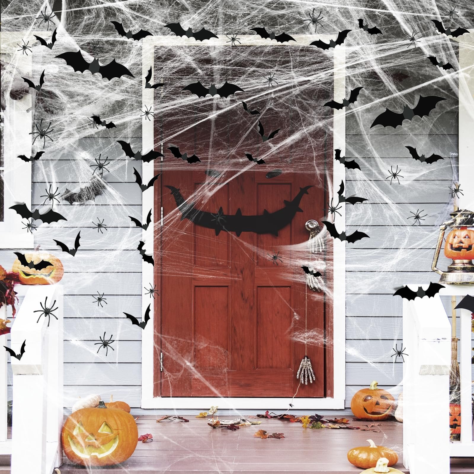 Halloween porch decorated with fake spider webs, bats, spiders, and pumpkins.