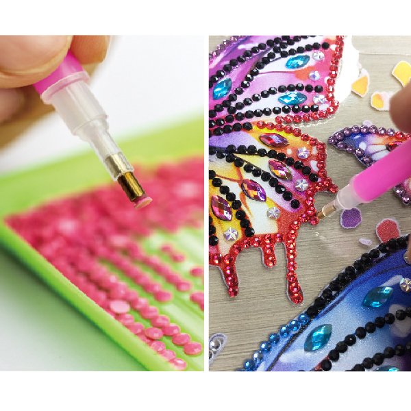 Close-up of diamond art kit showing pink diamonds in a tray and a tool placing rhinestones on a butterfly design.