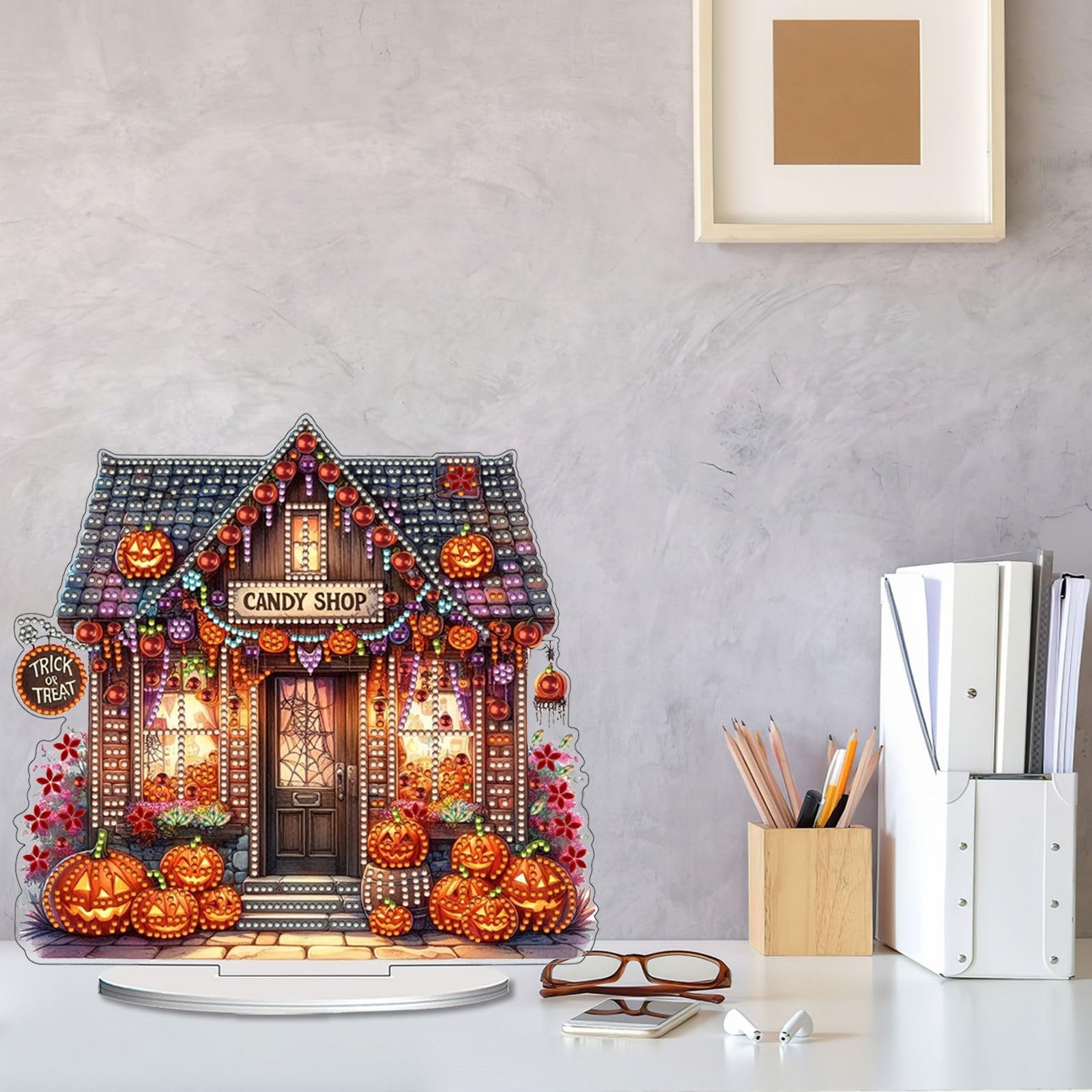 Halloween candy shop tabletop ornament with pumpkins and lights, displayed on a desk.