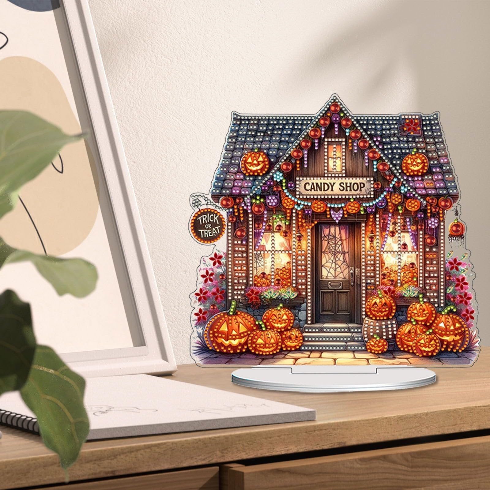 Halloween candy shop tabletop ornament with pumpkins and lights, displayed on a desk.