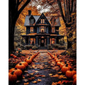 Halloween house with pumpkins lining a path, surrounded by autumn trees and fallen leaves.