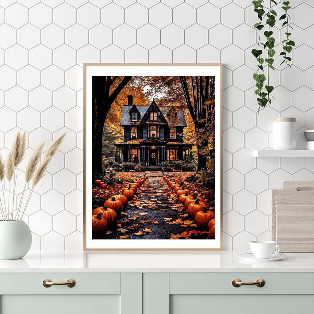 Framed painting of a dark, haunted-style house with a path lined by pumpkins and fallen leaves, set against an autumn forest backdrop.
