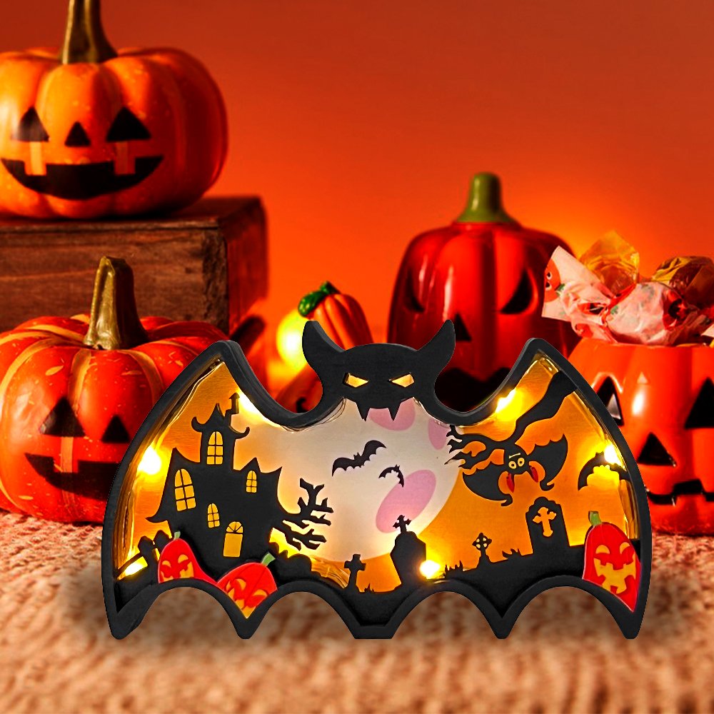 Light-up wooden bat shadow box with Halloween scene, surrounded by pumpkins.