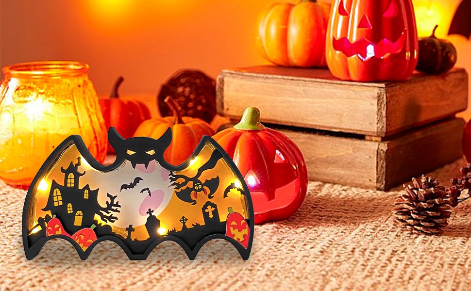 Light-up Halloween bat shadow box with haunted house, pumpkins, and bats, set against a warm, festive background with pumpkins and jars.