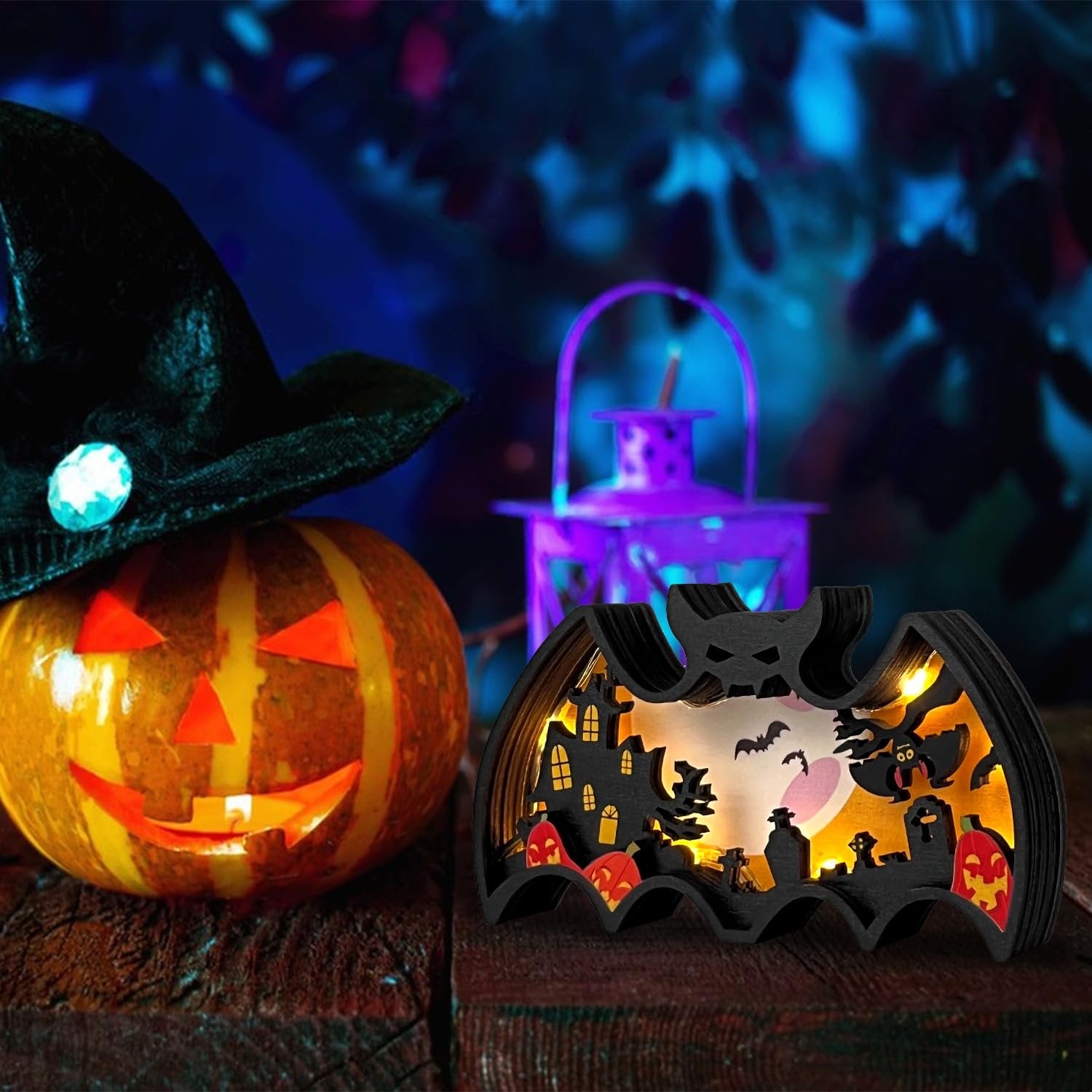 Halloween light-up bat shadow box with spooky scene, next to a carved pumpkin with a witch hat.