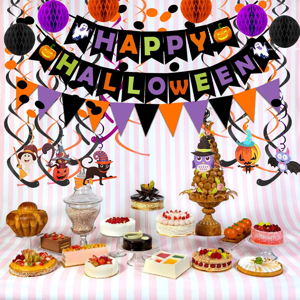 Halloween party decorations including a 'Happy Halloween' banner, honeycomb balls, swirl streamers, and character cutouts, set against a pink and white striped backdrop with a dessert table in the foreground.
