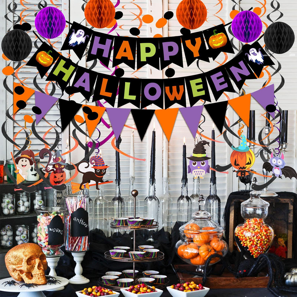 Halloween party table setting with decorations, candy, and pumpkins.