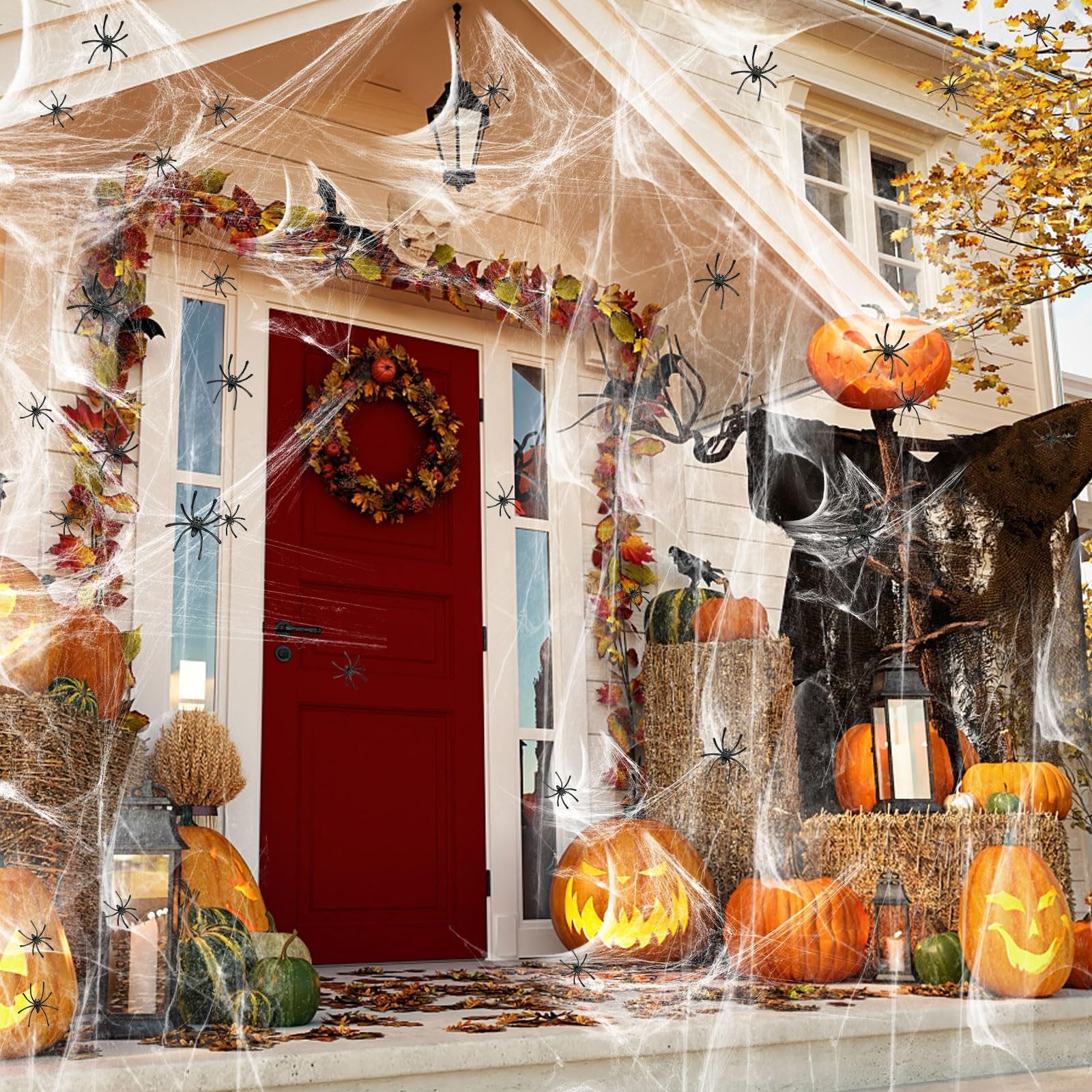 Halloween porch decorated with stretchable cobwebs, fake spiders, pumpkins, and a wreath on the door.