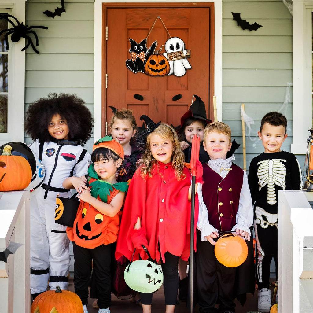 Children in Halloween costumes posing on a porch with pumpkins and decorations