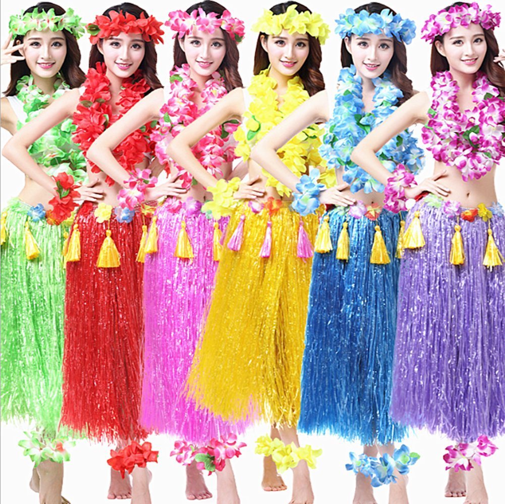 Six women in colorful Hawaiian hula outfits featuring leis, flower crowns, and grass skirts.