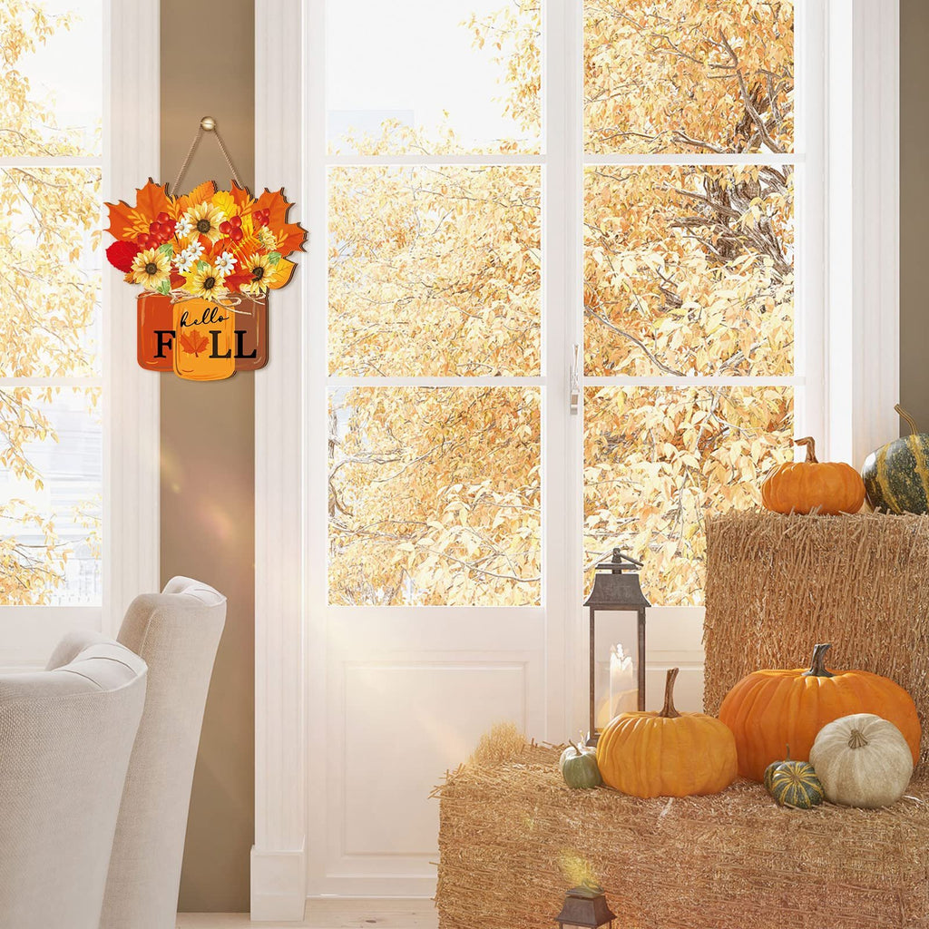 Autumn door sign with sunflowers and maple leaves hanging on a door with pumpkins and hay bales nearby